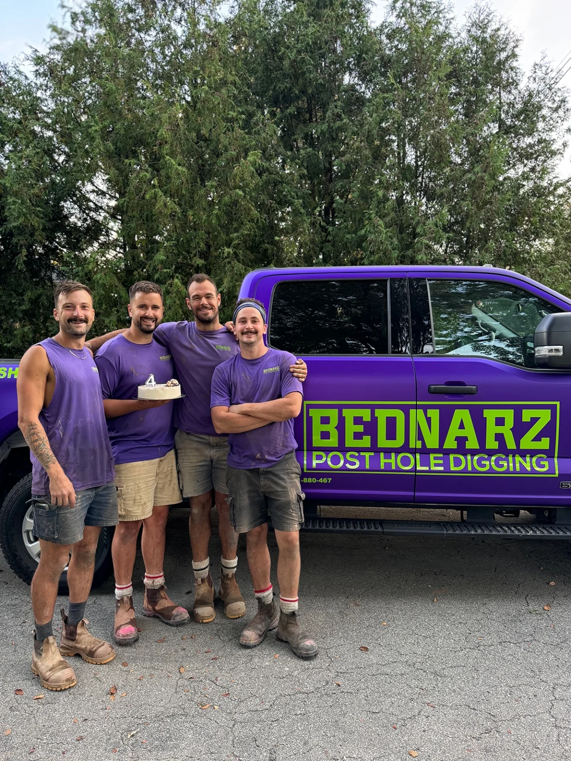 Bednarz crew team members in purple shirts posing with branded service truck Cambridge Ontario