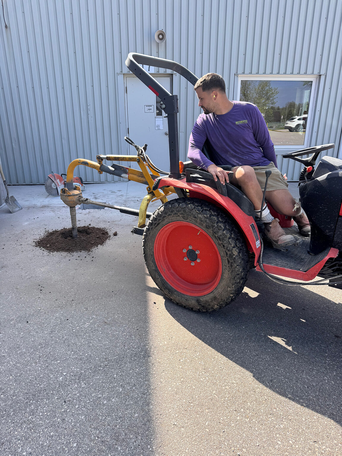 Bednarz operator on post hole digging equipment performing fence installation in Ayr Ontario