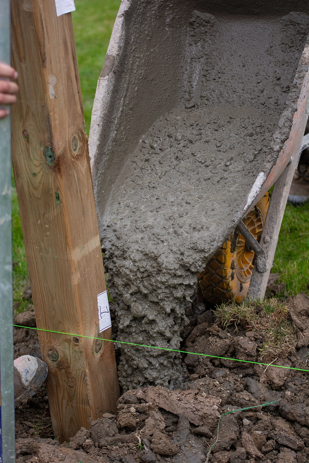 Bednarz hydraulic post hole auger machine digging fence post hole at Pickering residential property with rural homes in background