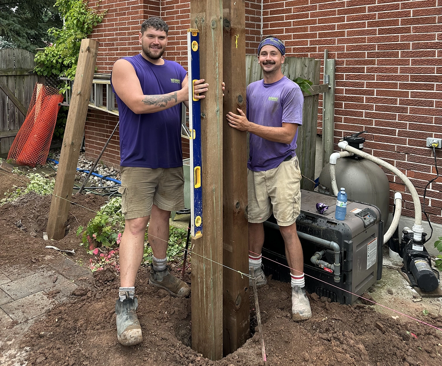 Bednarz crew installing deck footing post at residential Toronto property with professional equipment and concrete base