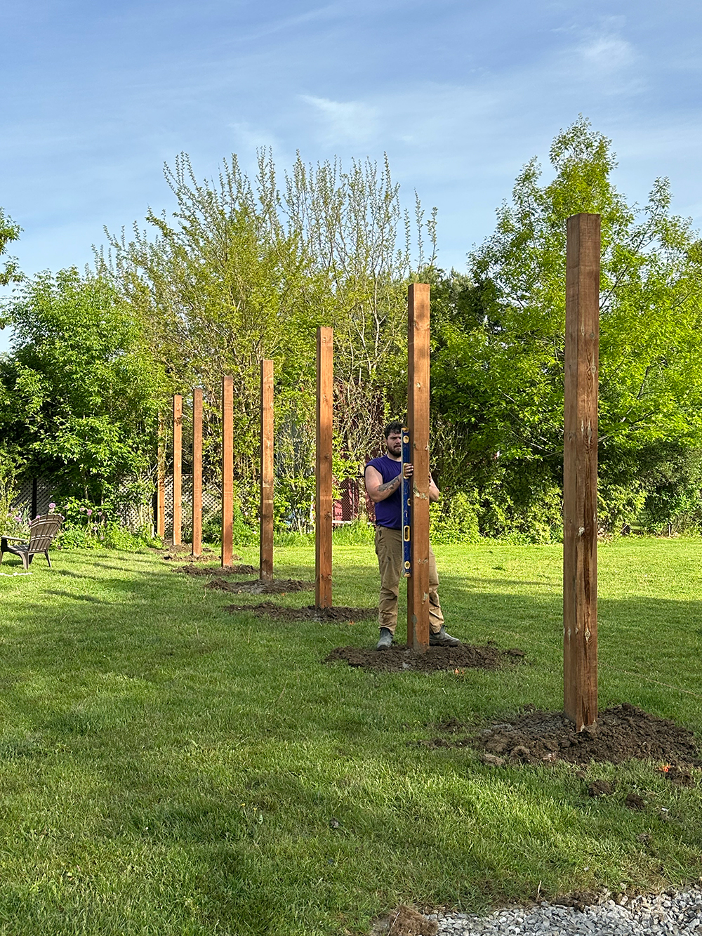 Two Bednarz crew members setting wooden fence posts for residential fence installation in Brampton Ontario