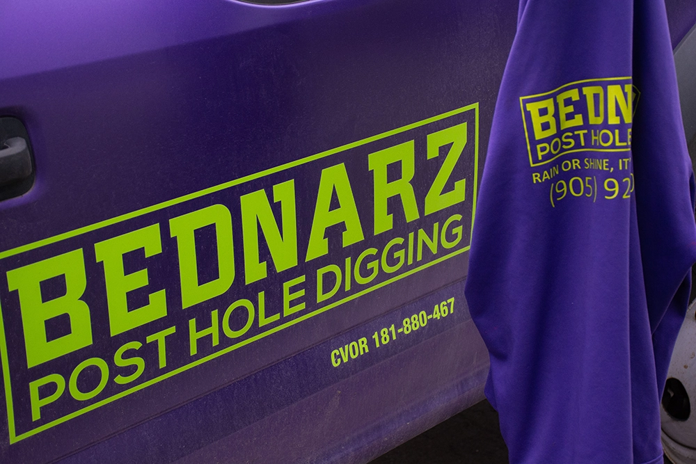 Bednarz vehicle branding visible during commercial fence post installation in Stoney Creek Ontario