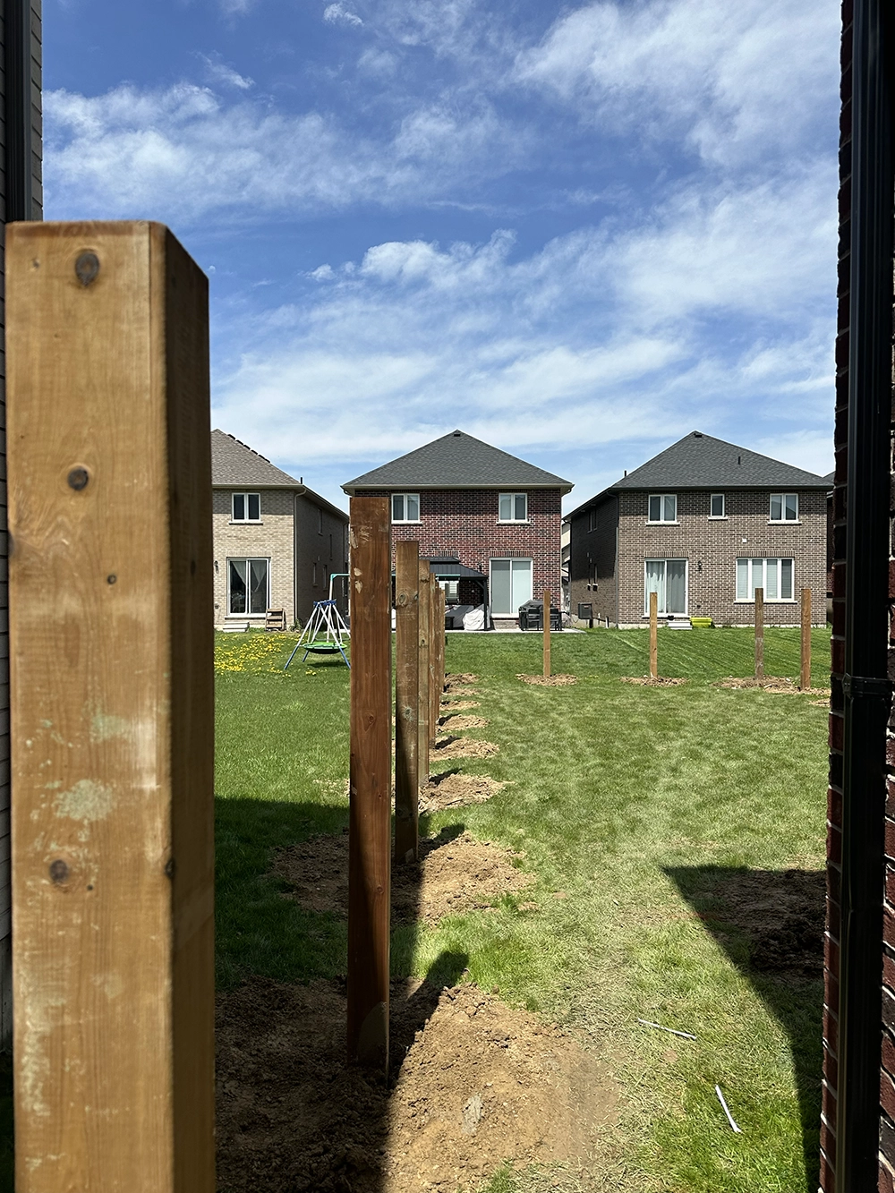 Wooden deck post footings set in ground showing post hole digging for deck installation in Simcoe
